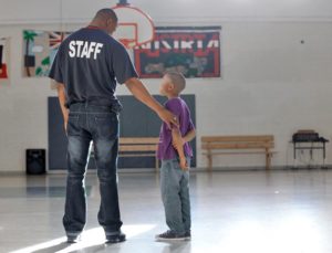 Staff and Young Boy on Basketball Court